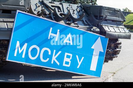 Cartello stradale blu con lettere bianche vicino al carro armato, sul territorio del Museo Nazionale di Storia dell'Ucraina. La guerra della Russia Foto Stock