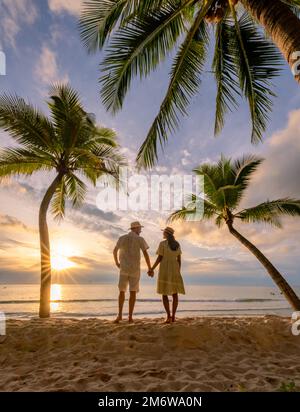 Spiaggia di Bang Tao Phuket Thailandia, coppia di uomini e donne che guardano il tramonto sulla spiaggia Foto Stock