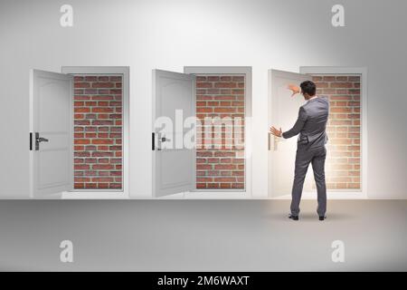 Uomo d'affari che guarda senza uscita con porta in mattoni Foto Stock