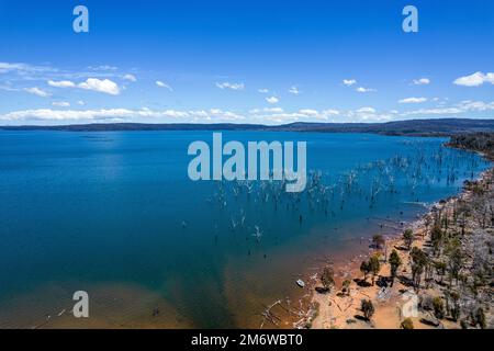 Una piccola barca sotto il vibrante cielo estivo blu sul lago Echo Tasmania. Foto Stock