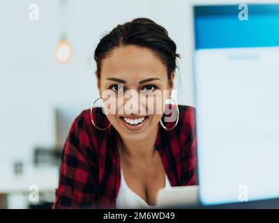 Donna seduto alla scrivania del luogo di lavoro tiene lo smartphone fisso al computer portatile, sincronizza i dati tra il computer e il gadget in ufficio, usin Foto Stock