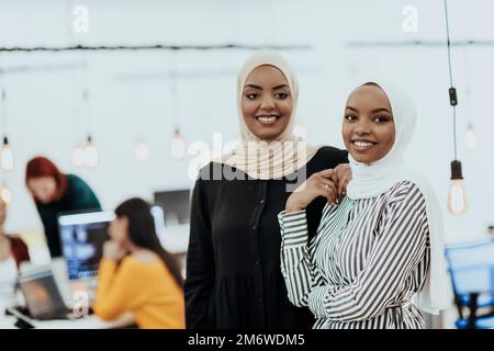 Ritratto di due donne d'affari afroamericane che parlano l'una con l'altra mentre si trovano in un moderno ufficio commerciale con il loro colle Foto Stock