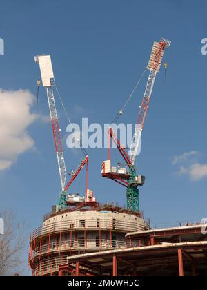 Sito in costruzione con molte gru contro il cielo Foto Stock