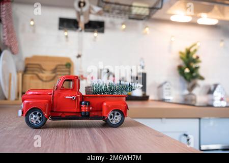 Una macchina rossa retrò con un albero di Natale decora la cucina festosa per Natale. Arredamento per la casa, festi Foto Stock