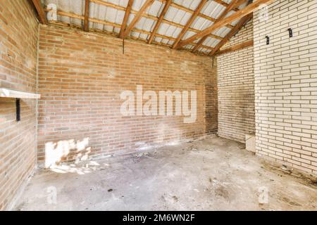 una stanza incompiuta con pareti in mattoni e travi in legno sul soffitto in una nuova casa in costruzione progetto foto stock Foto Stock