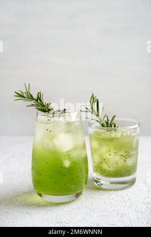 Due cocktail estivi in bicchieri sul tavolo grigio. Bevande fresche estive. Cocktail di frutta tropicale, muli tropicali. Foto Stock