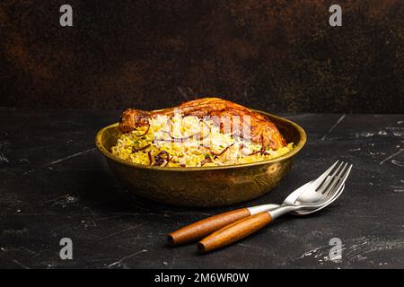 Piatto indiano pollo Biryani con riso basmati in metallo ottone vecchio ciotola sul tavolo Foto Stock