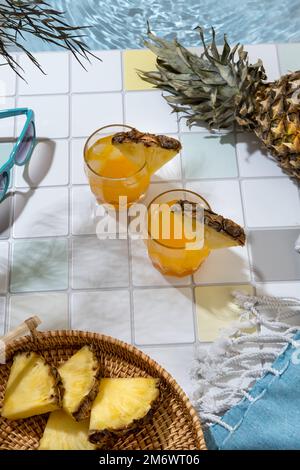 Due cocktail di ananas sul bordo della piscina. Vacanza estiva e concetto di viaggio. Bevande estive esotiche. Foto Stock