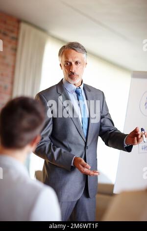 Mettendolo sul posto. Un taglio corto di un uomo fidato medio adulto che fa una presentazione sul lavoro. Foto Stock