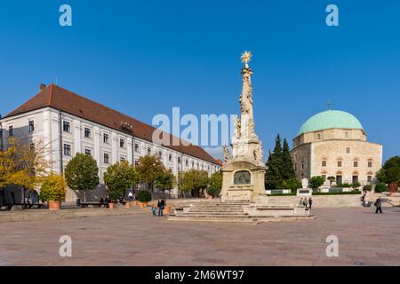 Vista sulla Piazza Szechenyi nel centro PÃ con la Statua della Santissima Trinità e la Moschea Pasha Qasim Foto Stock