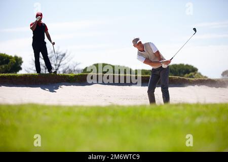 Entrare nel dondolo delle cose. due bei uomini che giocano una partita di golf. Foto Stock