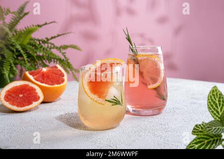 D'estate rinfrescanti cocktail spumanti con pompelmo. Limonata guarnita con rosmarino fresco. Bevanda estiva con acqua frizzante Foto Stock