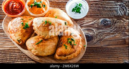 Composizione con un piatto di pierogi al forno Foto Stock