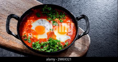Piatto shakshouka in una padella di ghisa. Foto Stock