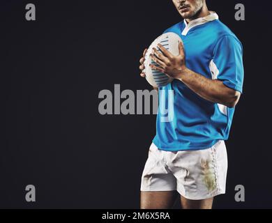 Vincere è tutto. Ripresa in studio di un giocatore di rugby su sfondo nero. Foto Stock