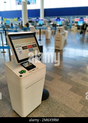 Macchina per il check-in self-service per il passaporto d'imbarco delle compagnie aeree in un aeroporto internazionale Foto Stock