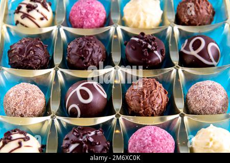 Foto ravvicinata di cioccolatini in una scatola su sfondo blu Foto Stock