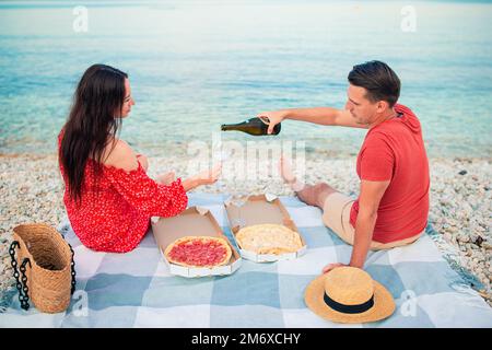 Bella giovane coppia che fa un pic-nic in spiaggia Foto Stock