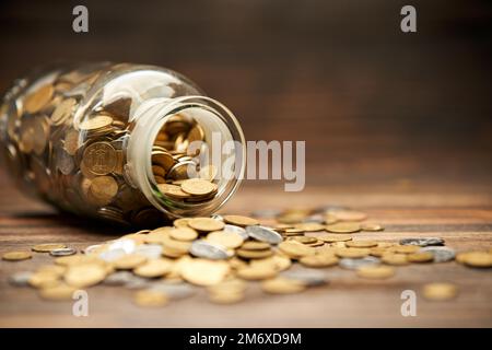 Vaso di vetro riempito di monete d'oro Foto Stock