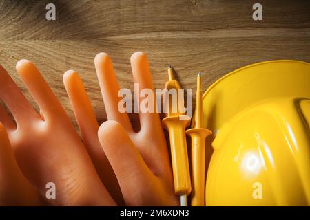 Tester elettrico cappuccio di sicurezza Guanti isolanti su tavola di legno. Foto Stock