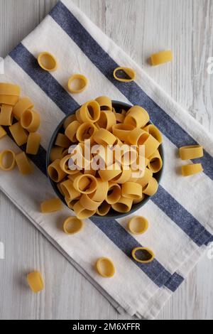 Pasta cruda non cotta Calamarata in una ciotola, vista dall'alto. Giacitura piana, sovratesta, dall'alto. Foto Stock