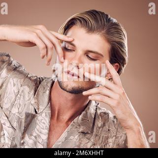 Bellezza, uomo e mani cornice viso, cosmetici e non binario con cura della pelle, manicure e bagliore su sfondo studio. Cura cosmetica, trucco e. Foto Stock