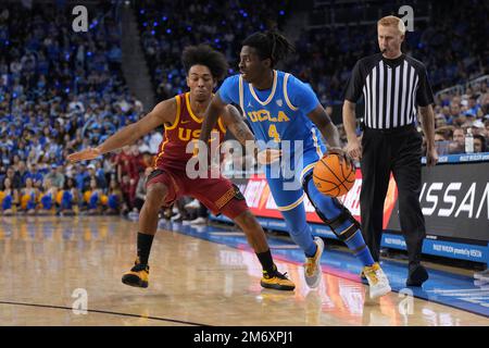 La guardia dei Bruins dell'UCLA Will McClendon (4) lancia la palla contro la guardia dei Southern California Trojans Malik Thomas (1) durante una partita di basket NCAA a Los Angeles, giovedì 5 gennaio 2023. UCLA sconfisse USC 60-58. Foto Stock