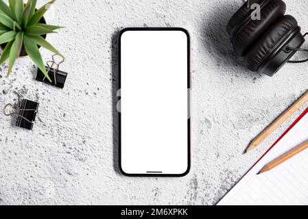 vista dall'alto dello smartphone con schermo vuoto sul desktop dell'ufficio in pietra bianca Foto Stock