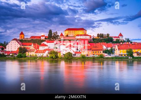 Ptuj, Slovenia. Scena notturna con la bellissima città più antica della storica Stiria, la riva del fiume Drava con il centro in cima alla collina. Foto Stock