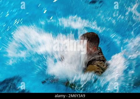 NEGLI STATI UNITI Soldato dell'esercito che gareggia nei 2022 Stati Uniti Army National Guard Region One Best Warrior Competition si tuffa nella piscina all'interno della Roland Hall presso la United States Coast Guard Academy, New London, Connecticut, 9 maggio 2022. Ogni soldato si immergerebbe nella piscina indossando un'armatura per il corpo e portando un'arma come parte del test di sopravvivenza dell'esercito in acqua. Foto Stock