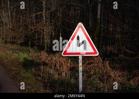 Successione di svolte a sinistra. Cartello stradale. Cartello stradale. indicazione successione di piegature, la prima delle quali è a sinistra. Foto Stock