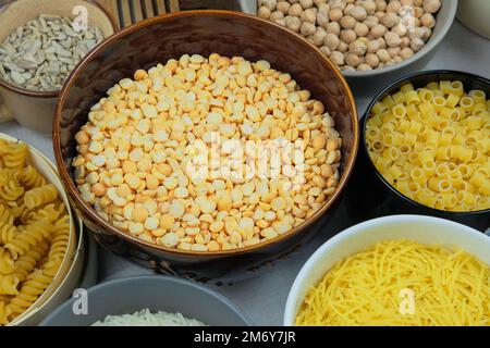 Piselli gialli in ciotola su fondo paglierino. Prodotto biologico vegetariano. Vista vintage. Foto Stock