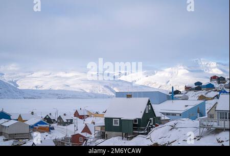 Case colorate aggrappate al lato della montagna sull'isola di Uummannaq, Groenlandia occidentale. Foto Stock