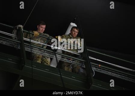 I sergente del personale dell'esercito Shawn Parks e Jamie Koopman guardano giù dalle travi del soffitto del Tyson Events Center a Sioux City, Iowa, mentre si preparano a rappellarsi sul bordo della passerella il 10 maggio 2022. I due soldati della Guardia Nazionale dell'Iowa hanno il compito di aiutare a consegnare un disco di gioco all'inizio del matchup di playoff della Sioux City Musketeers Hockey Western Conference il martedì sera. STATI UNITI Foto della Guardia Nazionale aerea Senior Master Sgt. Vincent De Groot Foto Stock