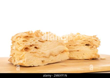 Due pezzi di torta di panna su un vassoio di legno, macro, isolato su sfondo bianco. Foto Stock