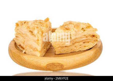 Due pezzi di torta di panna su un vassoio di legno, macro, isolato su sfondo bianco. Foto Stock