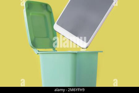 donna mano gettando in spazzatura mini piccolo cestino rifiuti può rotto smartphone carta tovagliolo bianco, fiammiferi bruciati o rotto sigaretta, batteria al litio Foto Stock