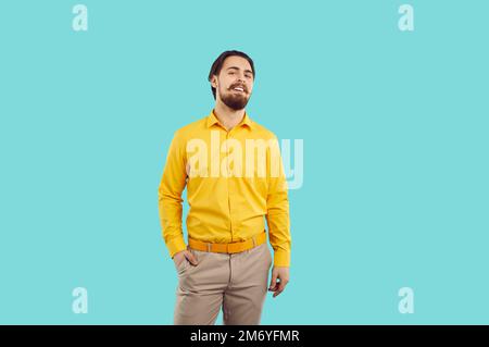 Studio ritratto di sorridente sicuro elegante uomo millenario isolato su sfondo azzurro. Foto Stock