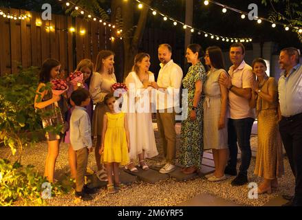 Cerimonia di matrimonio aperta. Sposa, sposo, uomo migliore, le bridesmaids intorno. Celebrazione del matrimonio all'aperto. Bouquet di fiori, anelli, voti. Amici felici. Celebrat Foto Stock