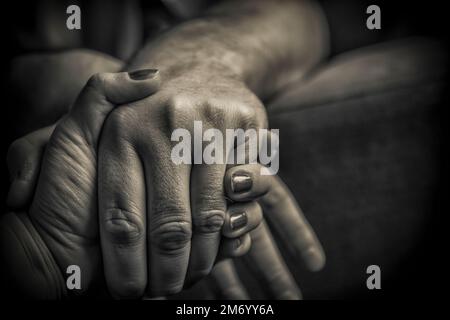 Primo piano tra uomo e donna che tengono le mani in bianco e nero Foto Stock