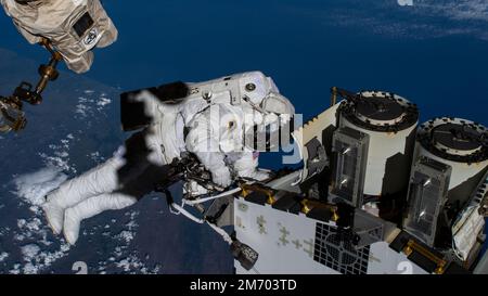 ISS - 22 dicembre 2022 - Expedition 68 Flight Engineer e lo spacewalker della NASA Josh Cassada cavalca il braccio robotico Canadarm2 per preparare un lancio di energia solare A. Foto Stock