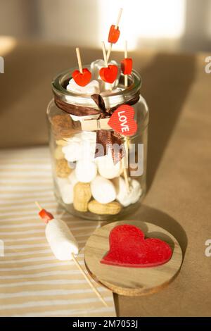 Dolce regalo per San Valentino con le tue mani. Un regalo per la vacanza fatto di caramelle a forma di cuore e marshmallows. Foto Stock