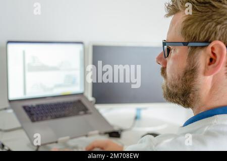 Programmatore di computer a scrivere il codice di un programma sul computer in ufficio Foto Stock