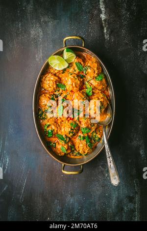 Polpette in salsa al curry in una terrina con cucchiaio Foto Stock