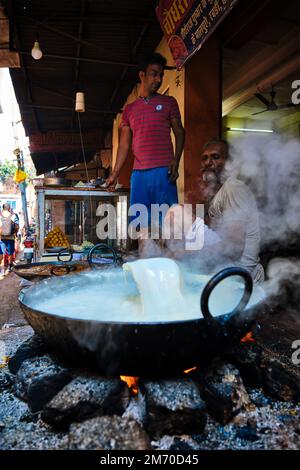 Pushkar, India - 7 novembre 2019: Street food stalle cuoco cottura dolce puri pane e rabi dolce, condensato-piatto a base di latte in strada di Pushkar Foto Stock