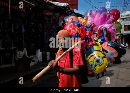 Uomo che vende palloncini nella strada di Pushkar, Rajasthan, India Foto Stock
