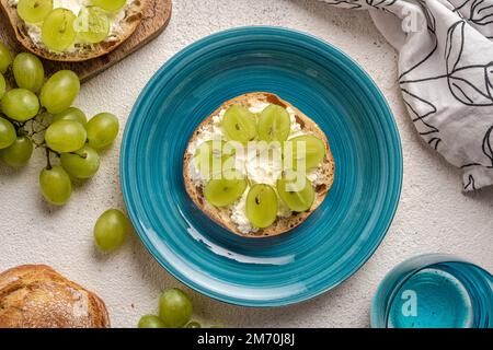 Panini con formaggio cremoso e uva. Foto Stock