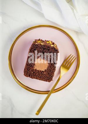 Torta da viaggio o torta tube o torta Voyage canache con tubo centrale riempito e glassa di cioccolato e pistacchio (può essere fatta con arachidi). Pagnotta al cioccolato Foto Stock