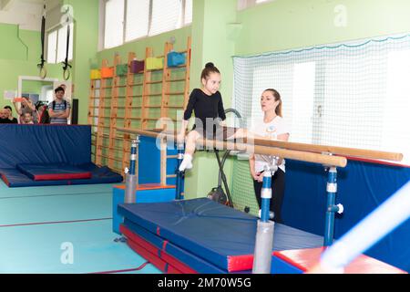 MOSCA, RUSSIA-DEC 18, 2022: Persone disuguale esercizio concorrenza ginnastica donna palestra ginnastica sport atleta forza ragazza femmina Foto Stock
