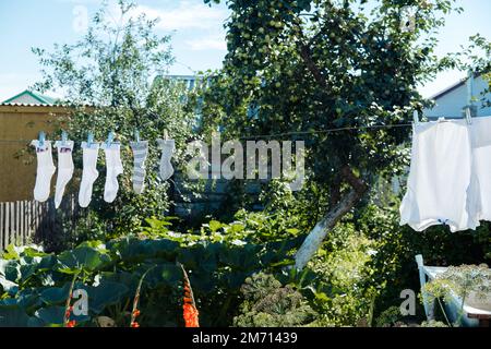 i vestiti lavati sui vestiti sono asciugati nel villaggio in una giornata di sole in estate Foto Stock